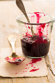 Berry jam in a glass with a spoon