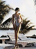 A young, short-haired woman wearing a red-and-white striped bathing suit