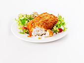 A breaded cod fillet with salad leaves