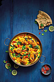 Keralan Style Roast Chicken Curry served with naan bread and topped with fresh chilli and coriander