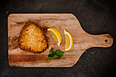 Schnitzel with lemon slices on a chopping board