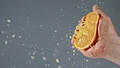 Squeezing an orange, slow motion