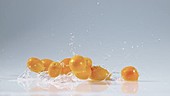Kumquats falling in water, slow motion