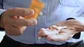 Man opening pill bottle