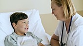 Boy in hospital bed with doctor