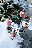 Various cupcakes on a cake stand in the snow