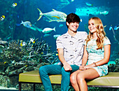 A young couple sitting in an aquarium