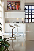 Bar stools in white kitchen with glossy cabinets