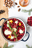 Poached pears with cranberries, cinnamon, rosemary and orange peel in a pot