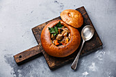 Beef meat soup Goulash stewed with potato, carrot and spices in Bread on concrete background