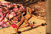 A blonde woman wearing a bikini lying on the sand