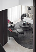 View of dark gray designer armchairs, coffee table and sofa in the living room