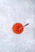 Roter Kaviar im Glas vor weißem Hintergrund (Aufsicht)