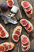 Sandwich with figs and goat cheese on wooden background