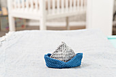 A blue and grey crocheted boat