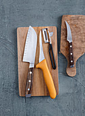 Kitchen knives, a peeler and chopping boards