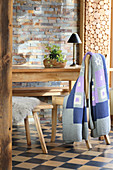 Hand-crocheted blanket on wooden chair next to table