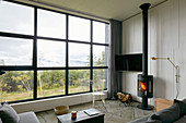 Wohnzimmer mit Blick durch Panoramafenster in die Landschaft
