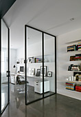 Glass and steel partition wall with door screening study
