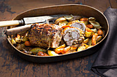 Oven-roasted stuffed shoulder of goat on a bed of colourful vegetables