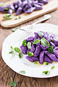 Purple potato dumplings with marjoram and broccoli