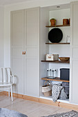 Fitted cupboards with shelving in niche and grey panelled doors