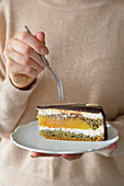 Woman holding a plate with cake, cake with orange jelly and chocolate