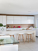 White modern kitchen with wooden elements and red accents provided by electrical appliances