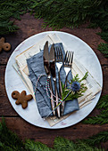 A Christmas table setting with cutlery and cookies