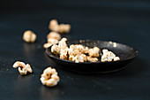 Vergoldetes Popcorn auf schwarzem Teller