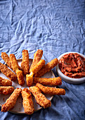 Breaded and fried halloumi sticks with a red pesto dip
