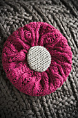 Cushion with knitted cover and knitted flower