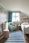 Child's bedroom in delicate shades with sloping ceiling