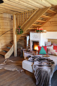 Cosy couch with cushions next to wood-burning stove