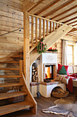 Wooden staircase next to wood-burning stove in log cabin