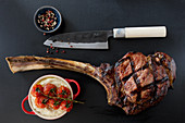 Grilled tomahawk steak with celery puree and tomatoes