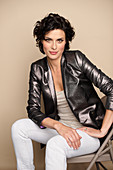 A dark-haired woman wearing a metallic blazer