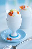 Scrambled eggs with yogurt and caviar in an eggshell