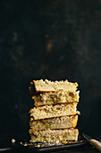 Several lices of crumb cake, stacked against a dark background