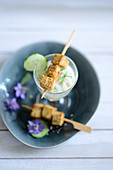 Cold cucumber soup served with tofu skewers