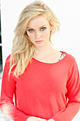 A young blonde woman wearing a red jumper