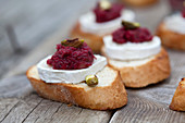 Crostini with goat's cheese, beetroot pesto and pistachios on toasted white bread