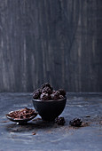 Brombeeren und Schokoladenraspeln in Schälchen vor dunklem Hintergrund