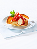 Vanilla ice cream with strawberry sauce, served in a tuile bowl