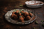 Home-made chocolate truffles with hemp oil on a silver plate