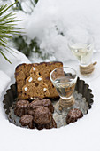 Mini chocolate Bundt cakes, honey cake and pear schnapps on a vintage tart tin in the snow