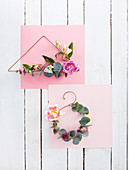 Minimalistische Blumenkränze auf gebogenem Draht und rosa Papier