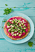 Low-carb tarte flambée with beetroot and quark hummus, feta cheese and cucumber