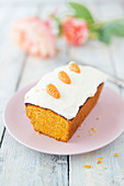 A mini carrot cake topped with cream cheese frosting and marzipan currents