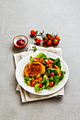 Vegan vegetable fritters with a mixed leaf salad and tomatoes